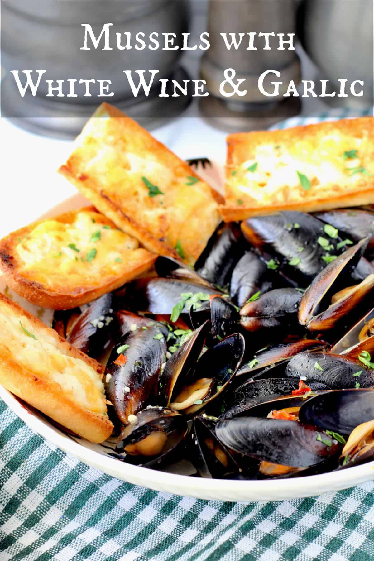 Mussels with White Wine and Garlic in a bowl with garlic bread on the side.