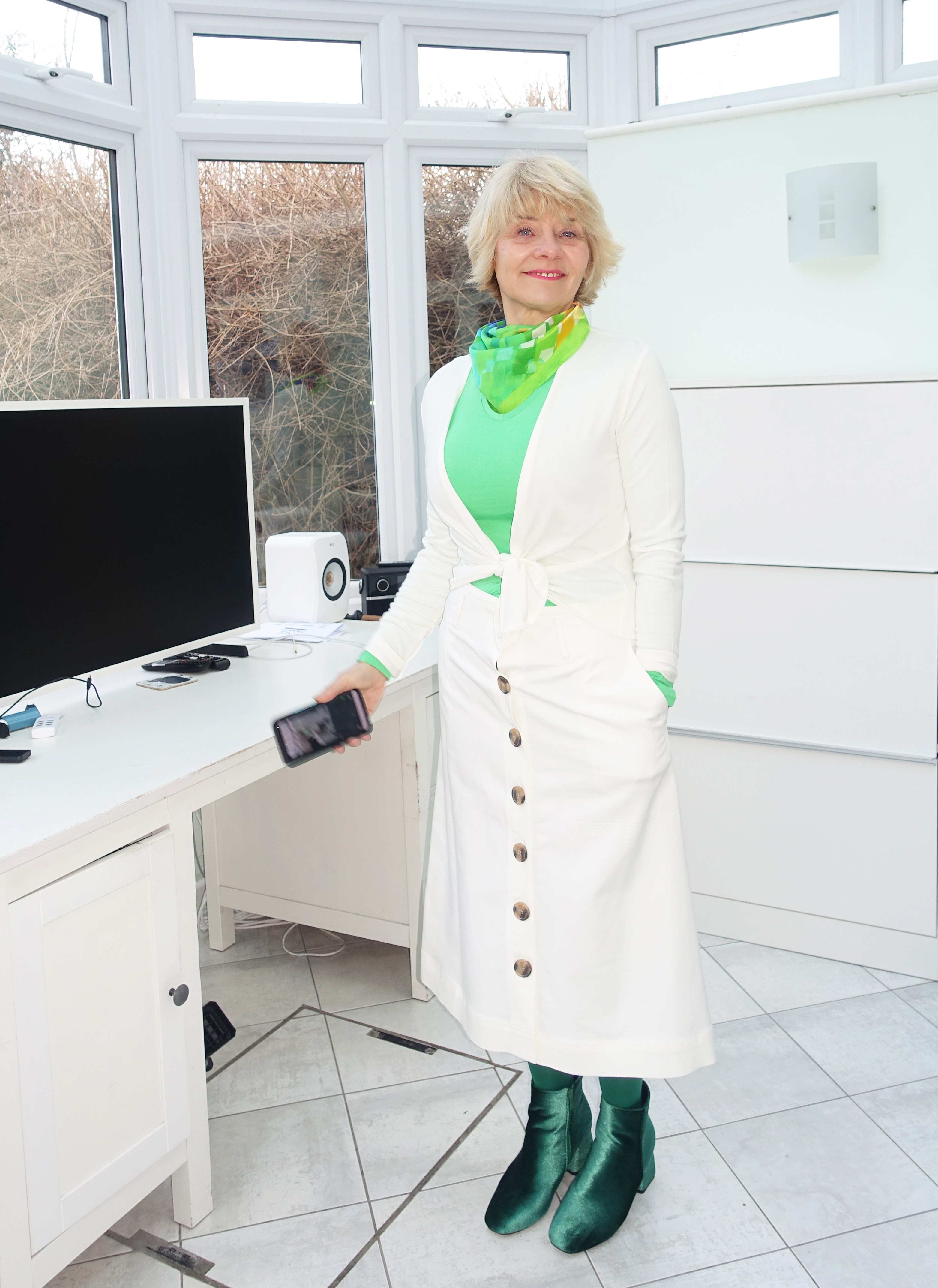A lot of white for winter in this outfit worn by Gail Hanlon from Is This Mutton: off white midi skirt and short tie wrap with a dash of green.