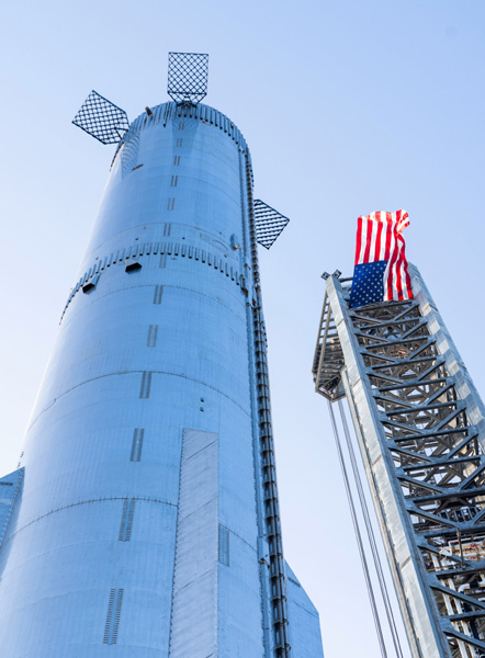 Starship Super Heavy's Booster 9 stands tall near the Orbital Launch Tower at Starbase in Texas...on July 20, 2023.