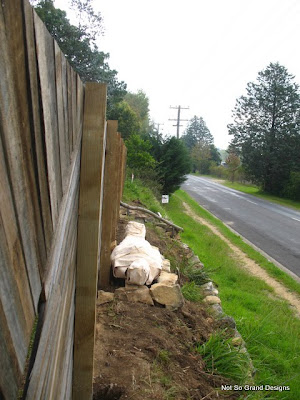  The white-wrapped 'corpse' lying along the base of the front fence, above the rock wall.