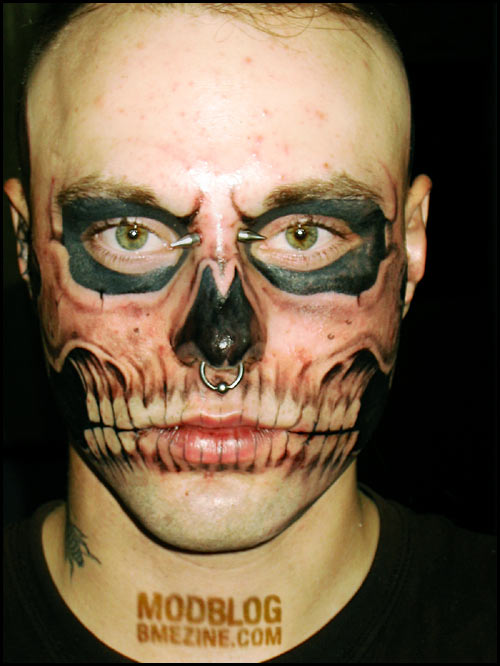 Face of a man looks into the skull after skull tattooed.