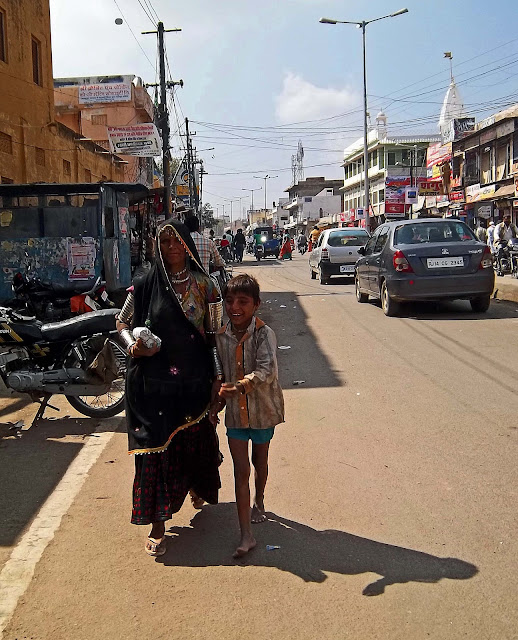 mother and son holding hands on street