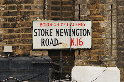 On a white background, red and black text says 'BOROUGH OF HACKNEY STOKE NEWINGTON ROAD, N.16.' The word 'OF' is in a smaller font and the stroke of the '6' extends above the height of the neighbouring characters.