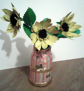 vaza din borcanel decorat cu servetel si trei flori galbene din carton
