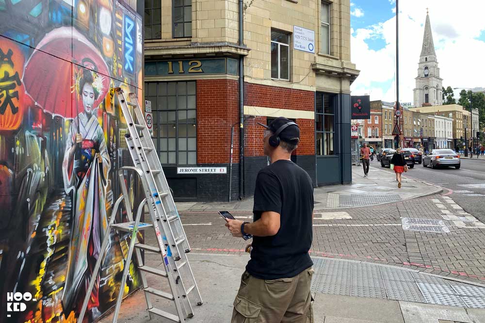 Dan Kitchener at work on his Geisha Street Art on Commercial Street, London