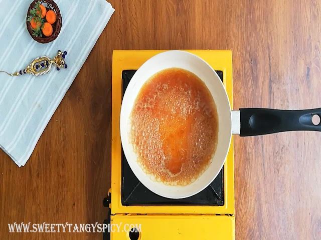 Jaggery melting in the saucepan over medium-high heat, forming a smooth and sweet syrup for the Inji Puli chutney.