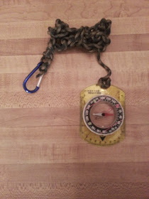 Brunton compass, connected to the belt via a carbiner and paracord