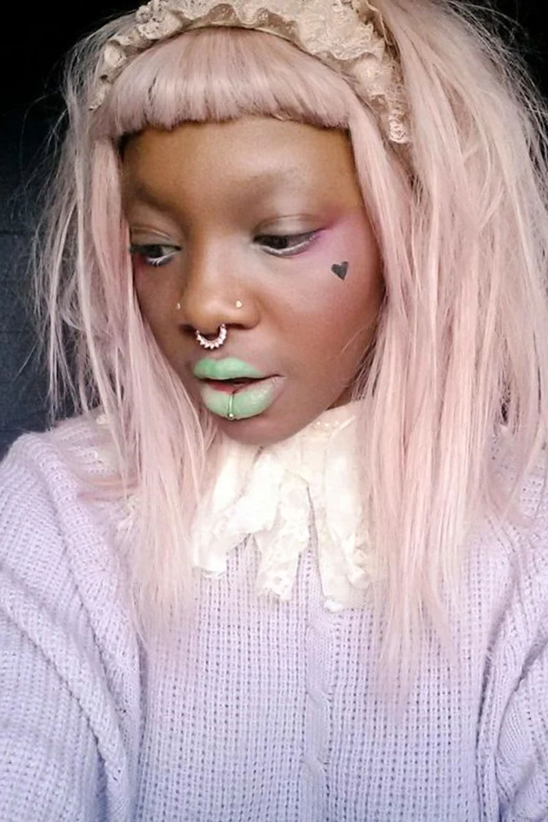 pretty selfie of a young woman with pastel goth makeup look and pastel mint lipstick