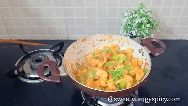 Freshly chopped coriander leaves are generously sprinkled over the Aloo Gobi, adding a vibrant touch and a burst of refreshing flavors to the final dish.