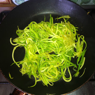 A serving of cooked zucchini pasta in a frying pan