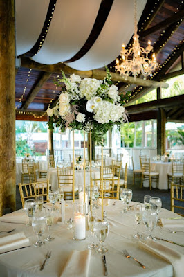 white and gold paradise cove reception with tall floral centerpiece on gold stand