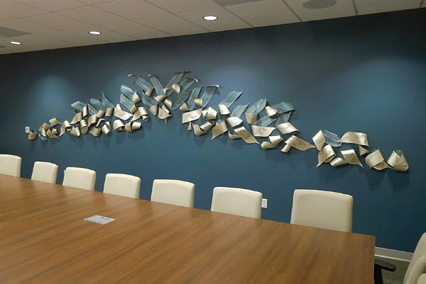 blue and ivory curled paper and metal horizontal wall sculpture with katagami handcarving displayed in boardroom