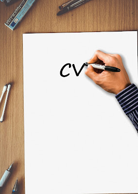 Persona escribiendo "CV" en un papel en blanco