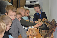 Dzieci oglądające wystawę zabawek z drewna.