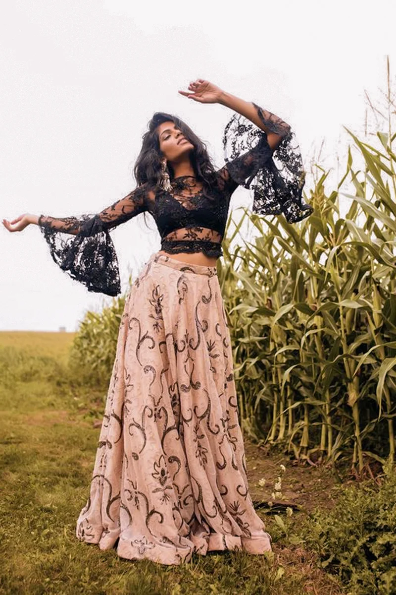 beautiful young woman in an eclectic witchy outfit is posing for the camera