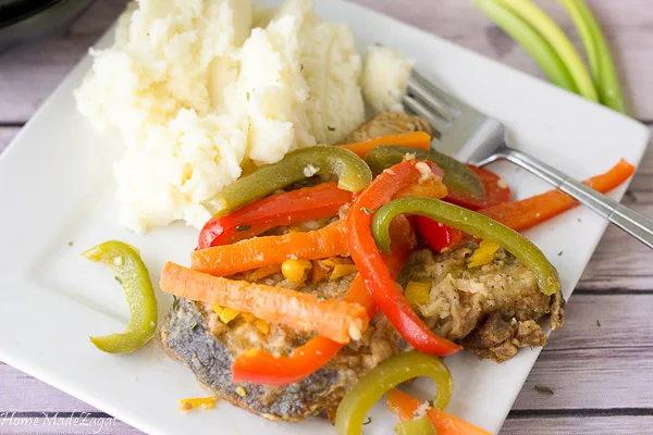 A plate of escovitch fish with a side of mashed potatoes