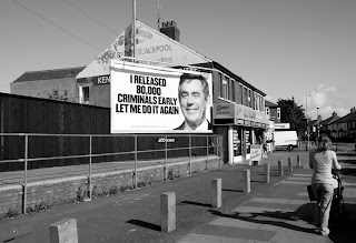 Billboard poster near some shops.