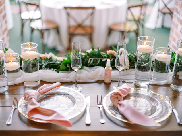 sweetheart table setup with gold rimmed charger and pink knotted napkins