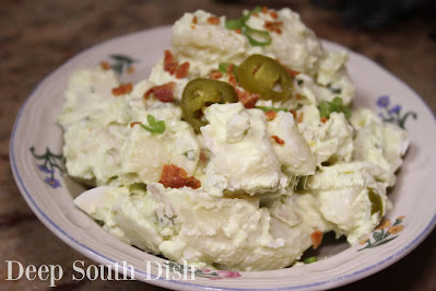 Potato salad, made with red and green onions, celery, jalapeno, cilantro and boiled eggs, tossed with a sour cream and avocado dressing.