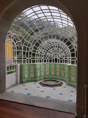 jardim de inverno com azulejos e teto em vidro
