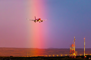 A PLAY aircraft arriving in a rainbow to celebrate pride.