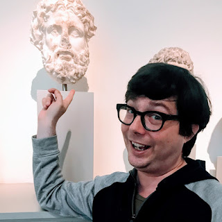 Greig Roselli stands next to a bust of Zeus at the Metropolitan Museum of Art Greek and Roman wing. 