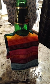 Beer bottle wearing a poncho.