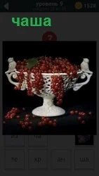 Красная смородина гроздями лежит в чаше и свисает по сторонам ветками с ягодами