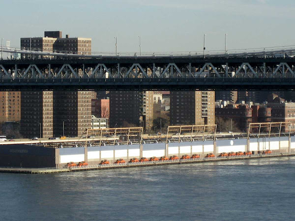 Thin Orange Line - A line of tractors past the Manhattan Bridge, from the Brooklyn Bridge.