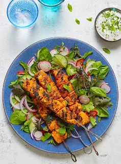 serving chciken tikka kebabs on the bed of salad