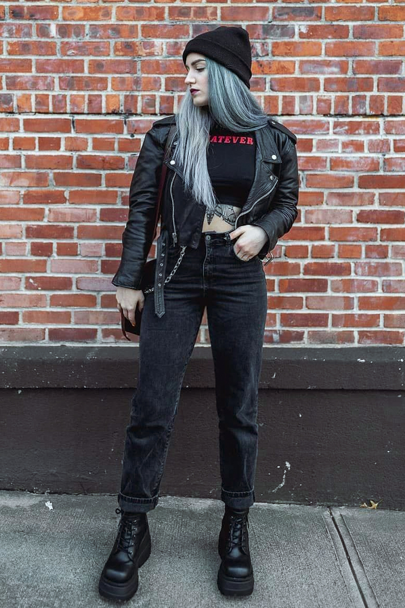 young woman wearing stylish grunge outfit and  a pair of dr martens boots posing on a street