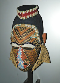 African wooden mask decorated with cowrie shells and beads 