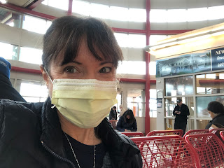 A selfie of me, wearing a mask, looking anxious on a metal bench at the Hamilton NJ train station.