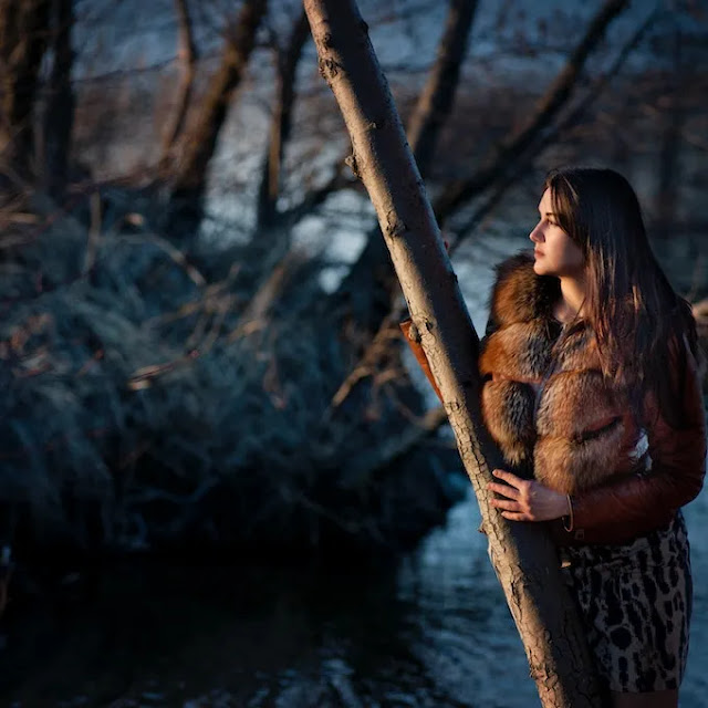 A very beautiful image of a very sexy girl in the forest wearing a furry jacket.