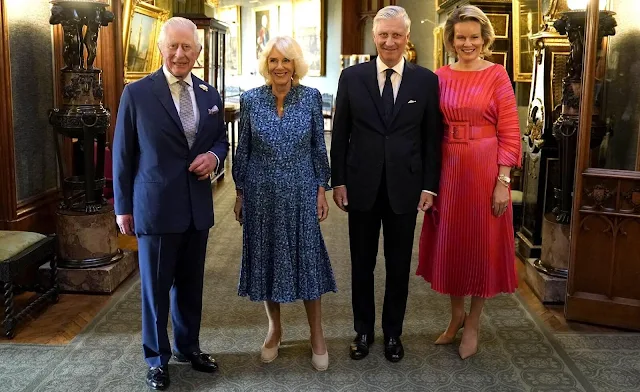 Queen Camilla wore a blue printed dress by Fiona Clare Aldridge. Queen Mathilde wore a Gabin printed pleated twill dress by Natan