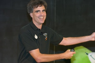 Randy Pausch with big and bright smile at his last lecture. He is wearing a black shirt and khaki pants.