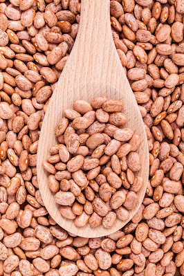 Pinto beans in a wooden spoon