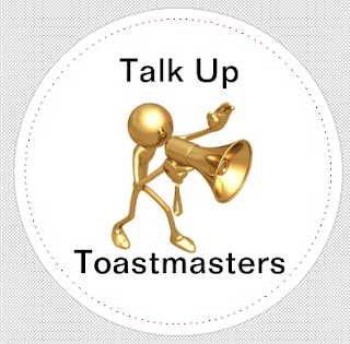 Image is of a three-dimensional stick figure style cartoon holding a megaphone. The text says, "talk up Toastmasters"