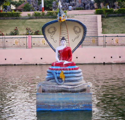 Buddha in the coils of the Mucalinda serpent, in the center of a lake in Bodh Gaya.