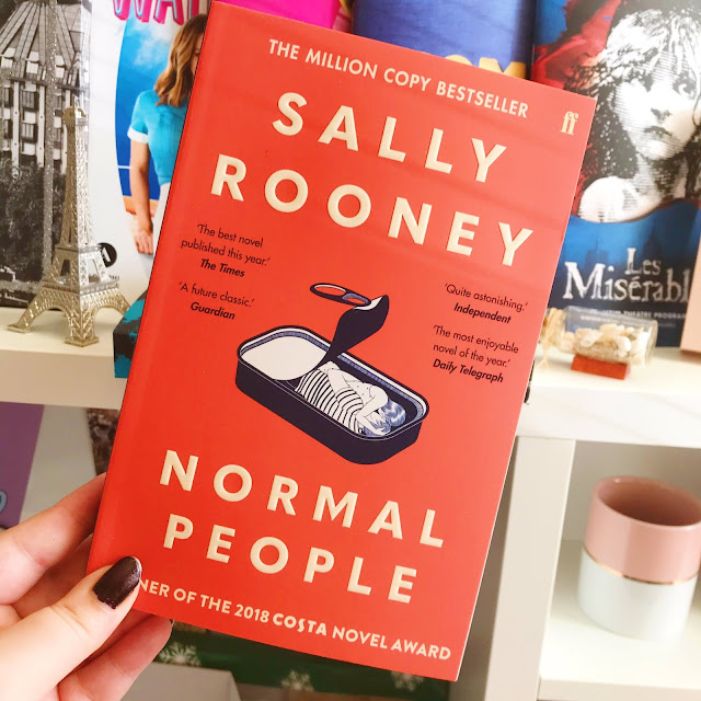 Normal People by Sally Rooney held up in front of musical programs on desk