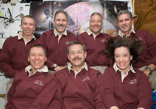 The STS-125 crew poses for a photo on the middeck of space shuttle Atlantis.