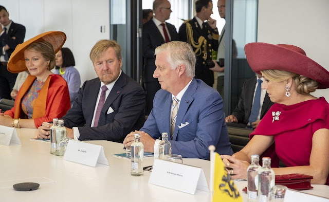 Queen Maxima wore a red midi dress by Natan. Queen Mathilde wore a metallic floral jacquard midi dress by Dries Van Noten