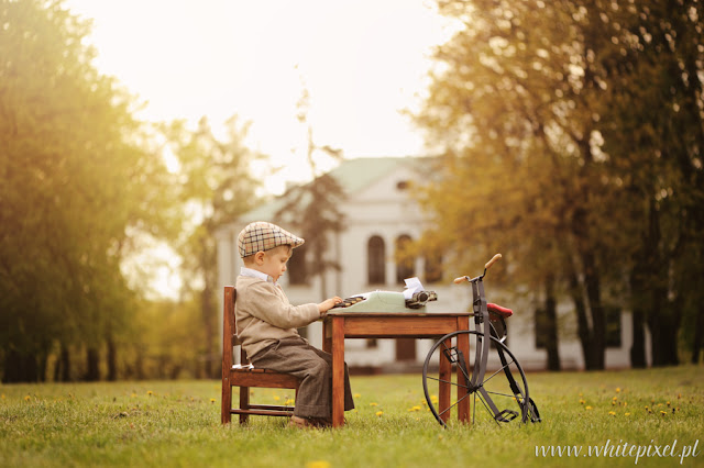 Chłopiec na fotografii stylizowanej, wiosennej, pisze na maszynie przy pałacyku w Lublinie i kraśniku