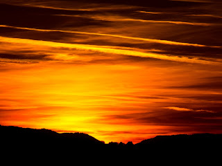 The sun being reflected in the clouds giving a very nice orange color