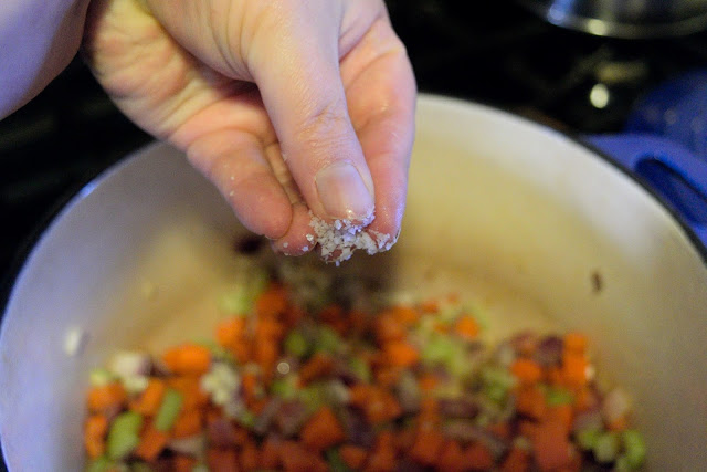 The garlic and vegetables being seasoned with salt and pepper.