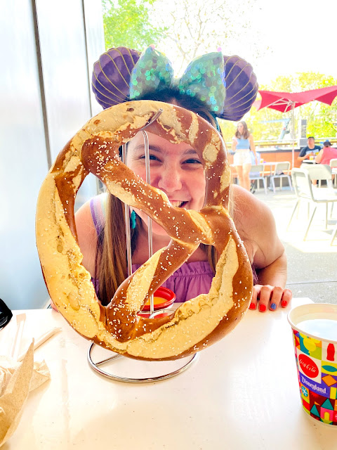 Jamie Allison Sanders smiling with the Quantum Pretzel from Pym Test Kitchen at Avengers Campus in California Adventure.