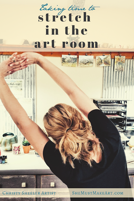 Taking time to stretch in the art room by Christy Sheeler Artist.  Artist stretching with arms linked above her head.