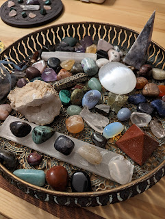 a collection of a wide variety of crystals in different shapes and sizes in a green tray on a table