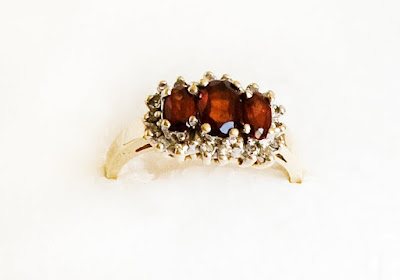 gold ring with 3 oval garnets surrounded by small diamonds