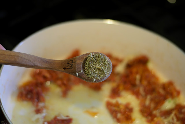 Italian seasoning being added to the pan. 